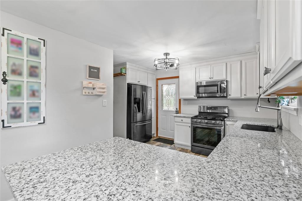 217 McMichael Road Carnegie, PA 15106 - Photo 13 of 38 a kitchen with stainless steel appliances granite countertop a refrigerator stove top oven and sink
