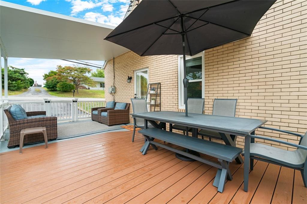 217 McMichael Road Carnegie, PA 15106 - Photo 4 of 38 a view of a roof deck with table and chairs under an umbrella with wooden floor