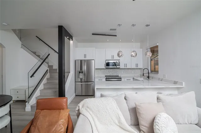 a kitchen with stainless steel appliances kitchen island granite countertop a refrigerator and a sink