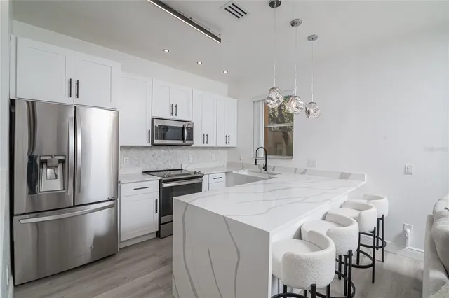 a kitchen with stainless steel appliances a refrigerator stove microwave and cabinets