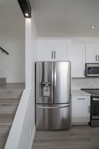 a kitchen with metallic refrigerator and a sink