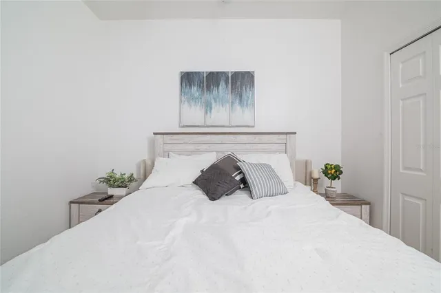a bedroom with a bed and painting on the wall