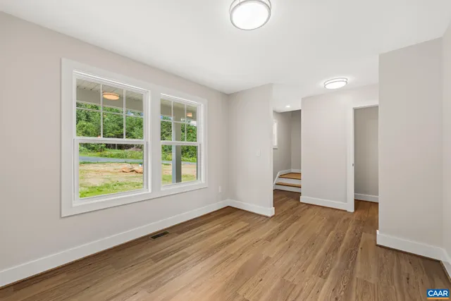 a large kitchen with a wooden floor and a ceiling fan
