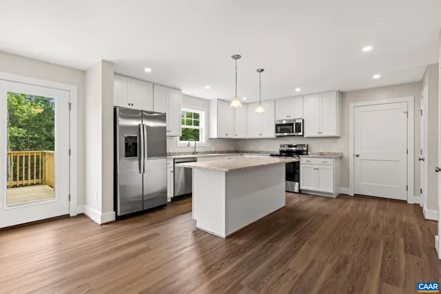 a kitchen with stainless steel appliances a refrigerator and wooden floor