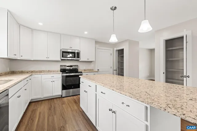a view of a kitchen with a refrigerator and a stove top oven