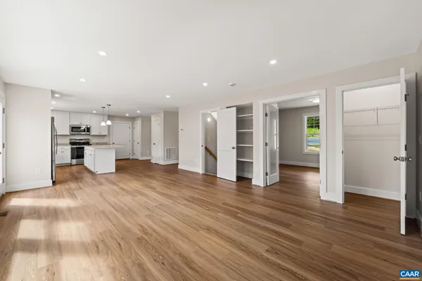 an empty room with closet and a hallway