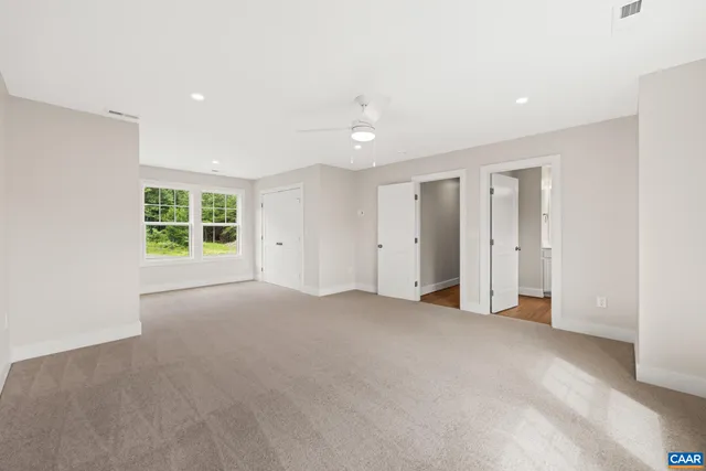 an empty room with a window and a ceiling fan