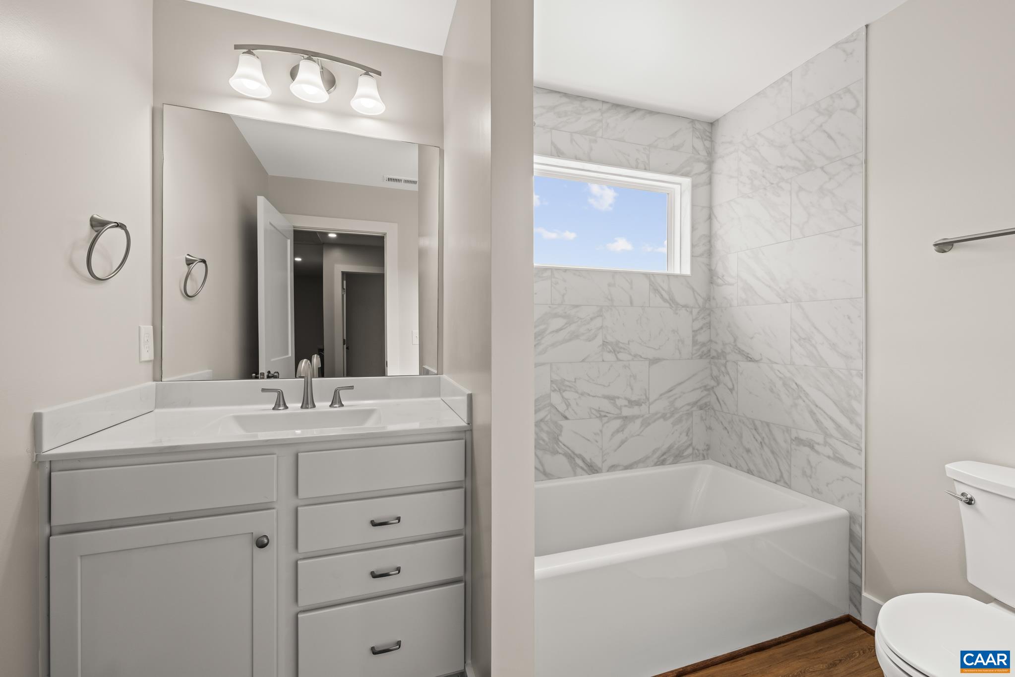 242 Palmer Place Ruckersville, VA 22968 - Photo 43 of 69 a bathroom with a sink a toilet a mirror a vanity a bathtub and shower