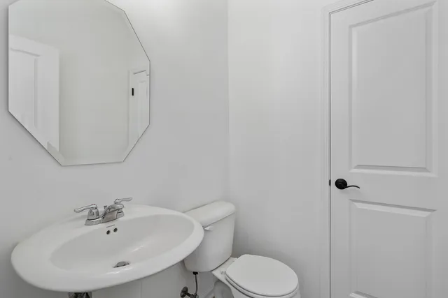 a bathroom with a sink mirror and toilet