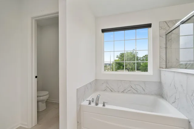 a white bath tub sitting next to a toilet
