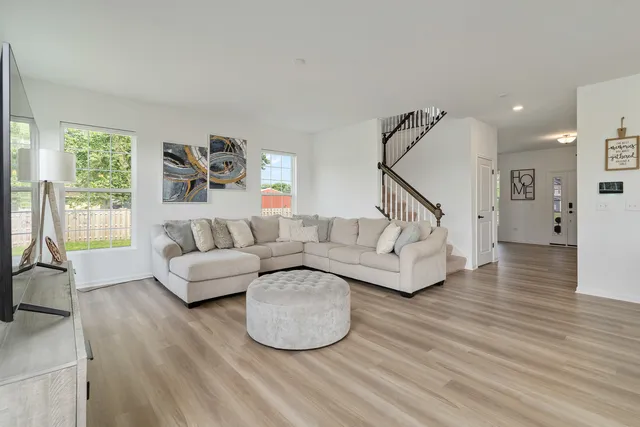 a living room with furniture and a wooden floor