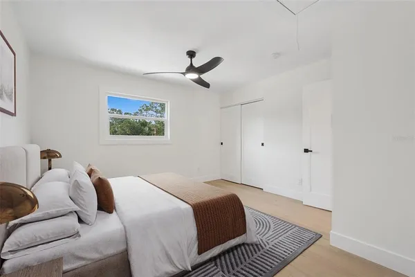 a bedroom with a bed and a ceiling fan