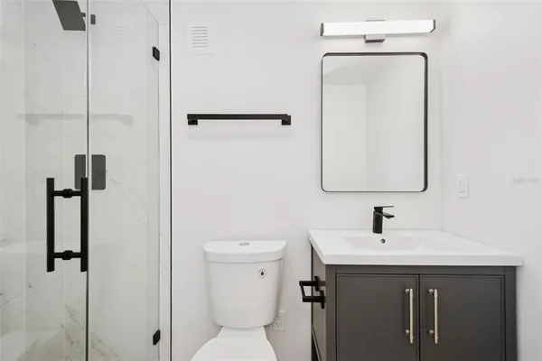 a bathroom with a sink toilet and mirror