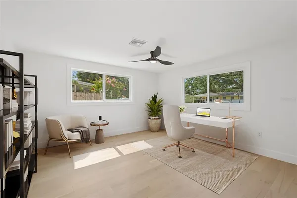 a living room with furniture a window and a potted plant