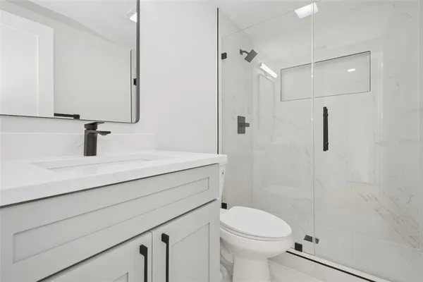 a bathroom with a sink a toilet and a mirror