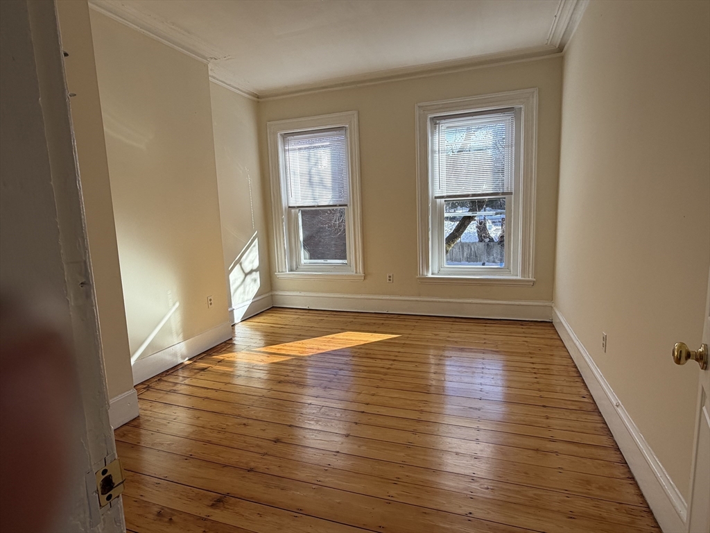 227 Roxbury Street, Unit 4 Boston, MA 02119 - Photo 6 of 7 wooden floor in an empty room with a window