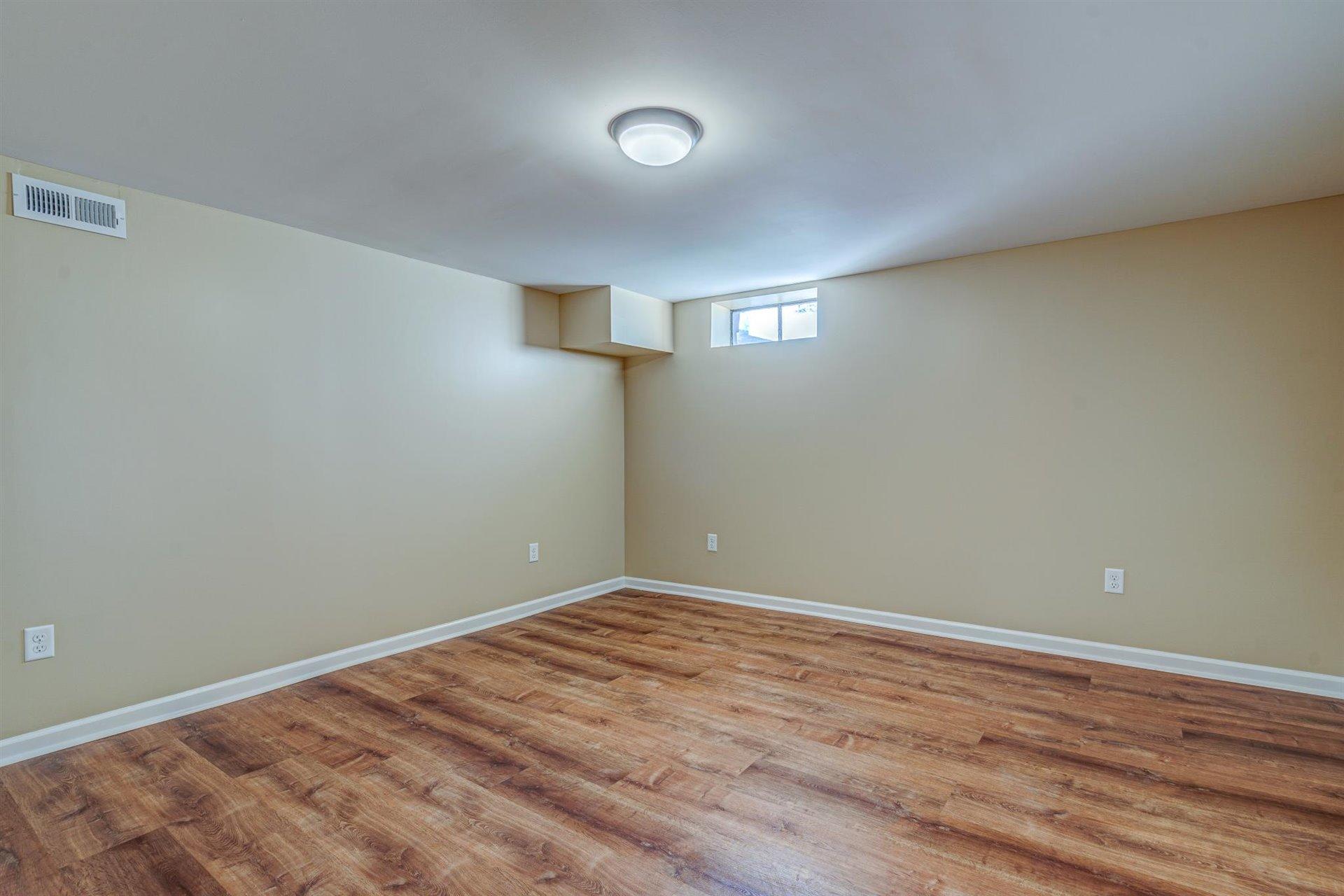 398 Jamestown Road Rocky Mount, VA 24151 - Photo 8 of 42 an empty room with wooden floor and windows