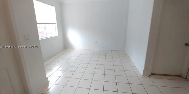 an empty room with white walls and tiles