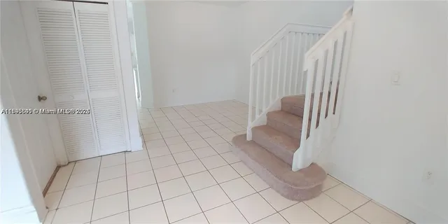 a view of an empty room and staircase