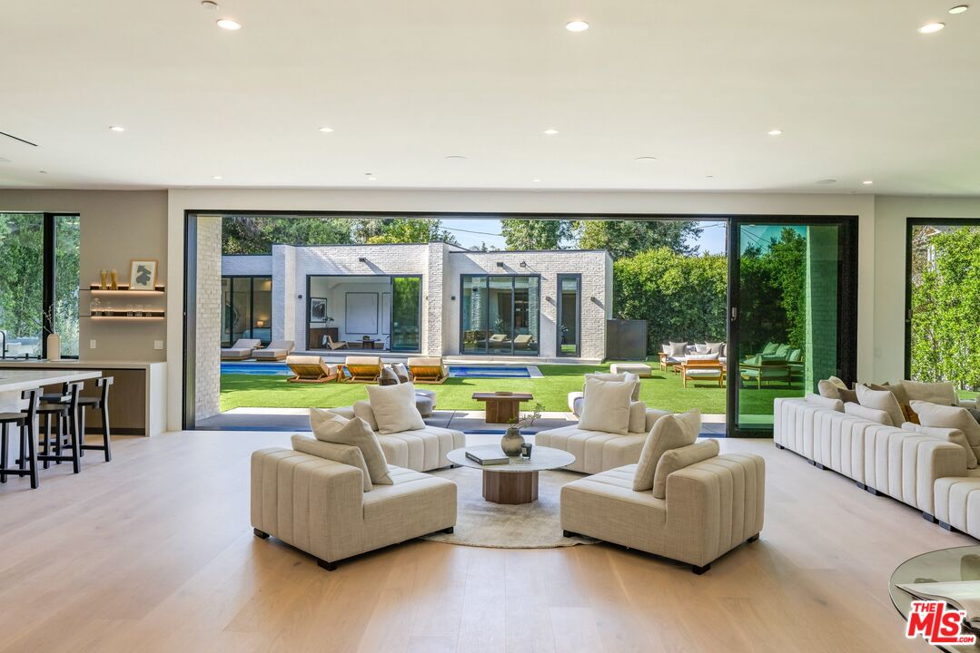 17055 Rancho Street Encino, CA 91316 - Photo 31 of 73 a living room with furniture and floor to ceiling windows