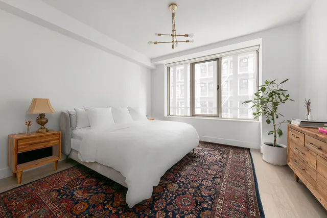 a spacious bedroom with a bed and a window