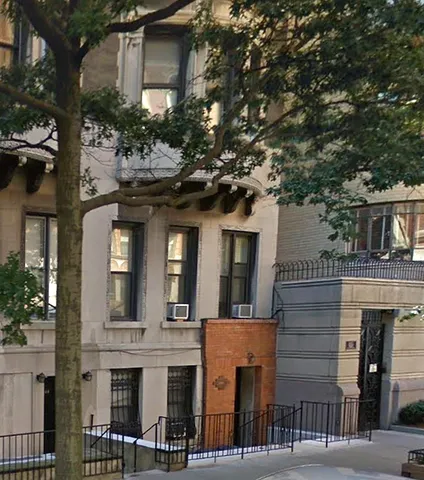 a front view of a house with a tree