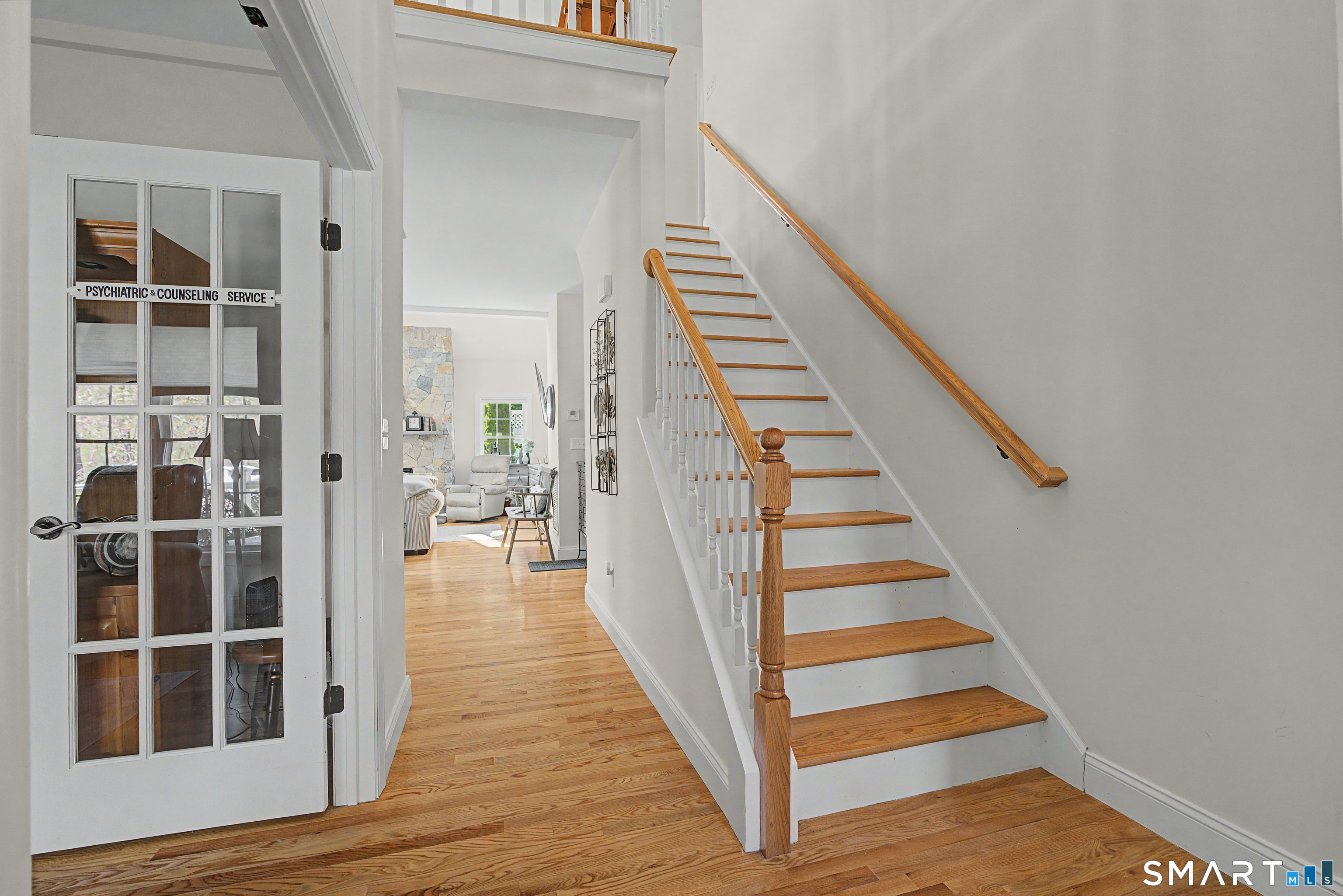 211 Meadowbrook Road, Unit 211 Oxford, CT 06478 - Photo 24 of 38 Welcoming foyer with hardwood floors and a graceful staircase, offering a bright and inviting first impression as you enter the home.