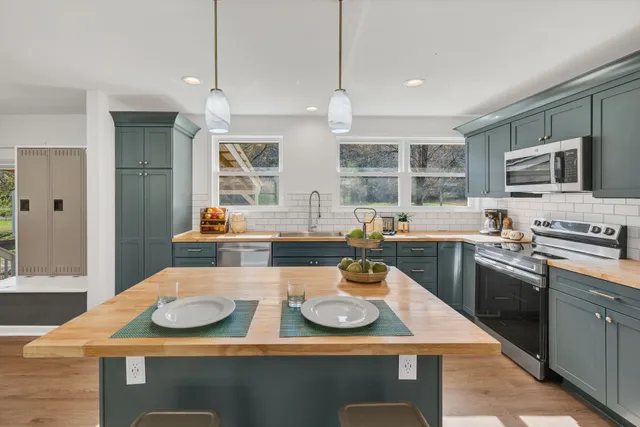 a kitchen with sink stove top oven and cabinets