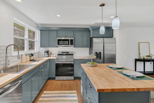 a kitchen with a sink refrigerator and microwave