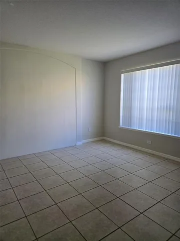 an empty room with chandelier fan