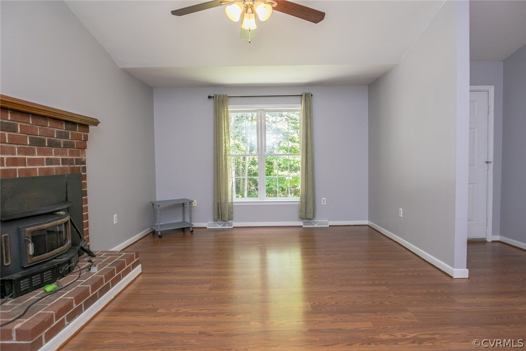 564 Jackson Road Bumpass, VA 23024 - Photo 2 of 36 a view of an empty room with wooden floor fireplace and a window