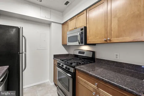 a kitchen with stainless steel appliances granite countertop a stove a refrigerator and a microwave