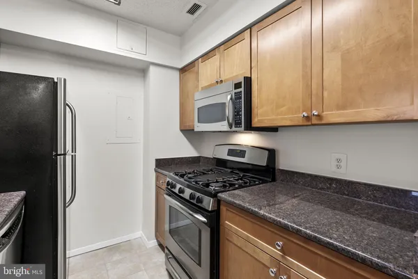 a kitchen with stainless steel appliances granite countertop a stove a refrigerator and a microwave