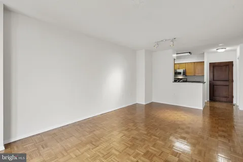 a view of a big room with wooden floor and a window
