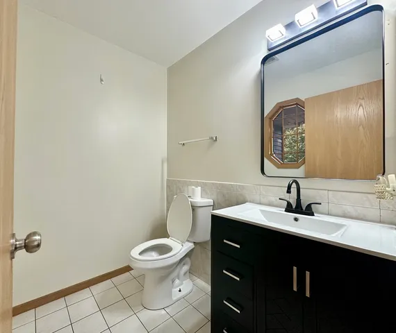 a bathroom with a toilet a sink and mirror