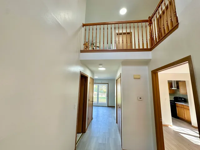 a view of staircase with wooden floor and pendant lights