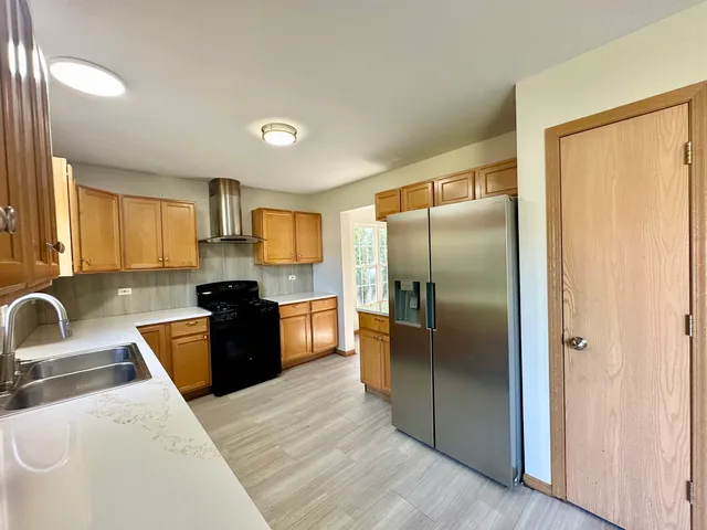 a kitchen with granite countertop a refrigerator and a sink