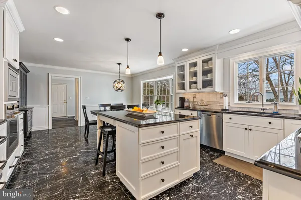 a kitchen with granite countertop white cabinets and appliances