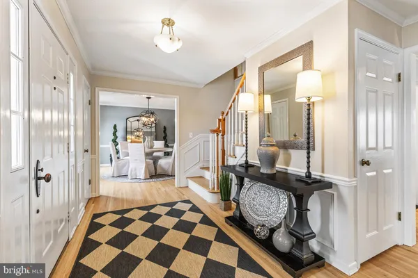 a view of a hallway with wooden floor and a bathroom