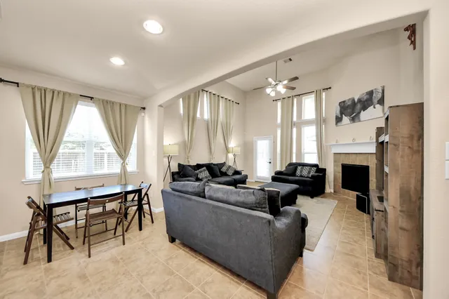 a living room with furniture a large window and a fireplace