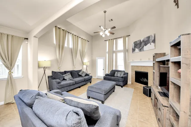 a living room with furniture a fireplace and a large window