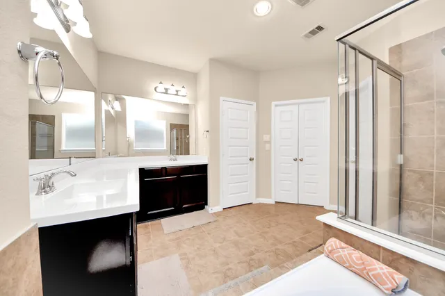 a spacious bathroom with a double vanity sink and mirror