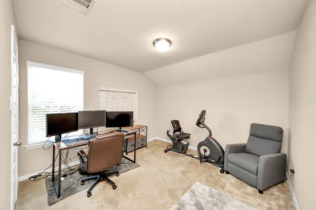 a view of a workspace with furniture and a window