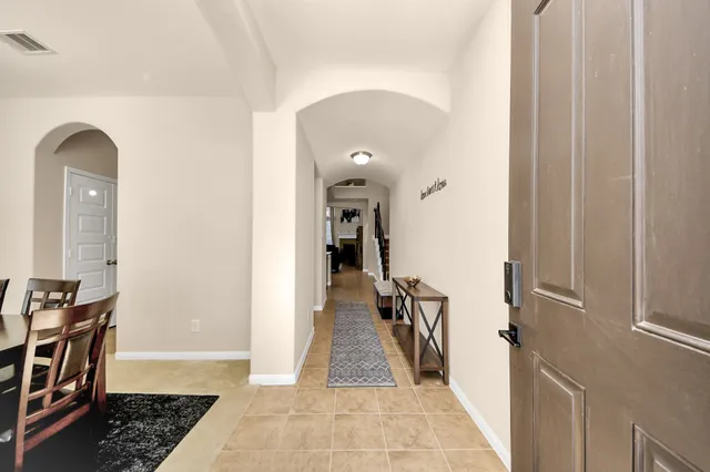 a view of a hallway with wooden floor and a living room