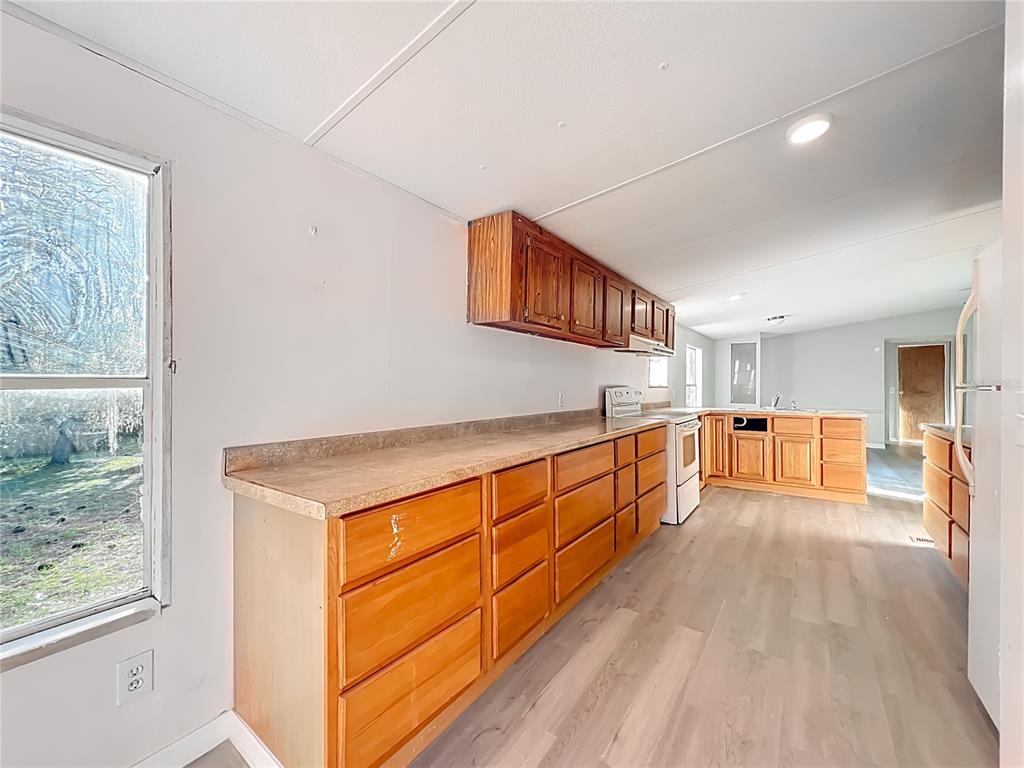 790 South Ebenezer Point Homosassa, FL 34448 - Photo 19 of 46 a large white kitchen with stainless steel appliances granite countertop a lot of cabinets and wooden floor