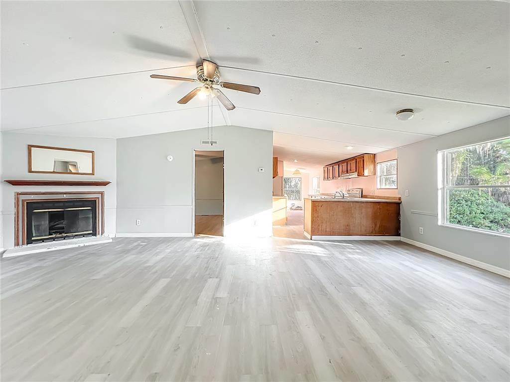 790 South Ebenezer Point Homosassa, FL 34448 - Photo 8 of 46 an empty room with wooden floor fireplace and windows