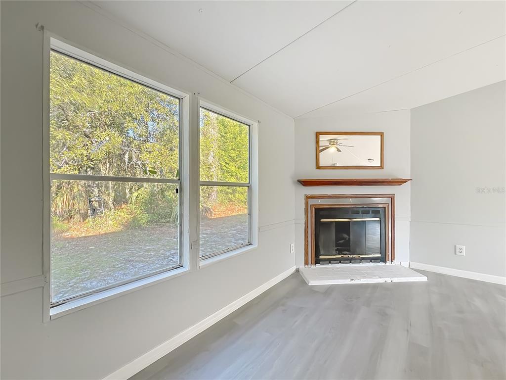 790 South Ebenezer Point Homosassa, FL 34448 - Photo 9 of 46 wooden floor fireplace and windows in an empty room