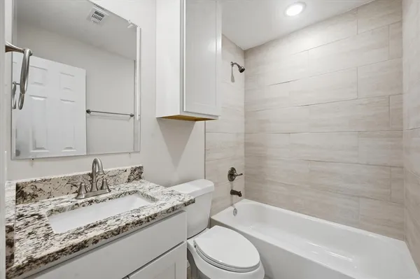 a bathroom with a granite countertop sink toilet and shower