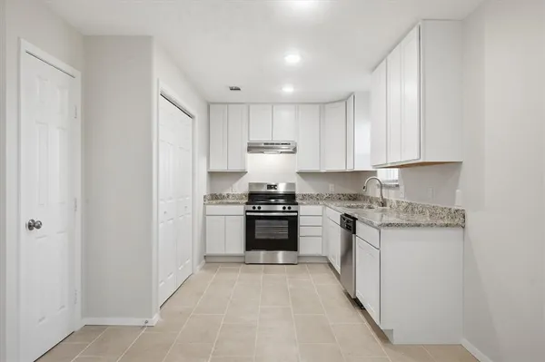 a kitchen with stainless steel appliances granite countertop a stove and a refrigerator
