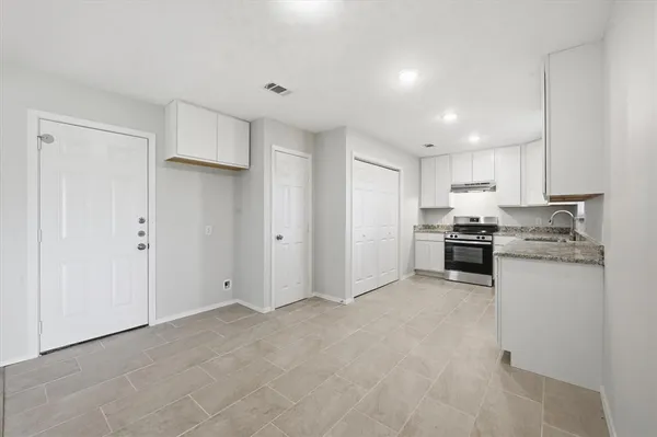 a kitchen with white cabinets and stainless steel appliances